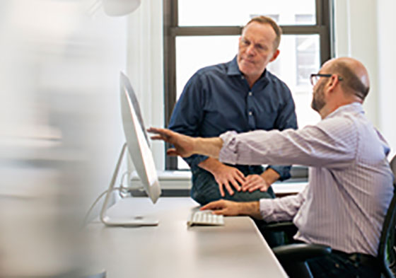 Two men sitting in front of a monitor Two men sitting in front of a monitor